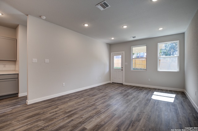 empty room featuring a healthy amount of sunlight and dark hardwood / wood-style flooring