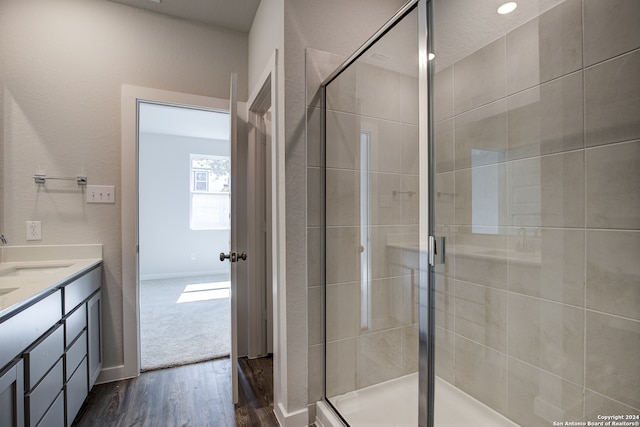 bathroom featuring hardwood / wood-style flooring, vanity, and an enclosed shower