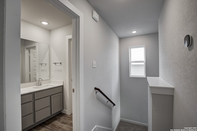 bathroom with hardwood / wood-style floors, vanity, and a textured ceiling