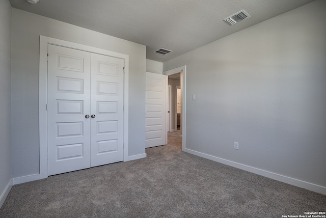 unfurnished bedroom featuring carpet flooring and a closet