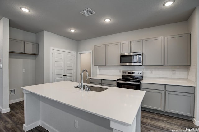 14518 Emerio Dr, San Antonio, TX 78253 - kitchen with dark wood finished floors, visible vents, gray cabinets, a sink, and appliances with stainless steel finishes