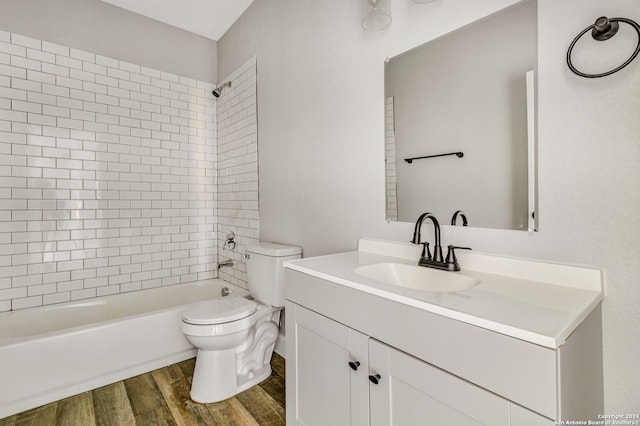 full bathroom featuring toilet, hardwood / wood-style floors, vanity, and tiled shower / bath