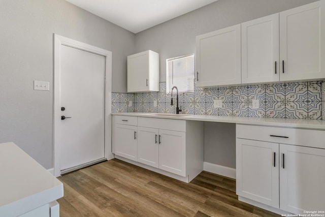 kitchen with decorative backsplash, white cabinetry, and sink