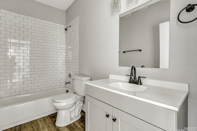 full bathroom with hardwood / wood-style floors, tiled shower / bath combo, toilet, and vanity