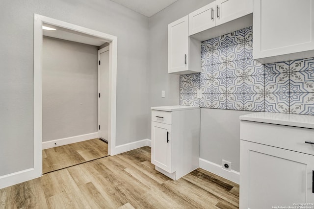 clothes washing area featuring light wood-type flooring