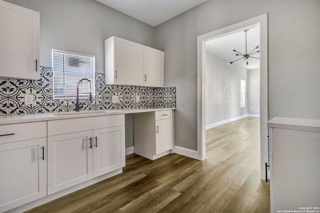 kitchen with white cabinetry, sink, dark hardwood / wood-style floors, and a notable chandelier