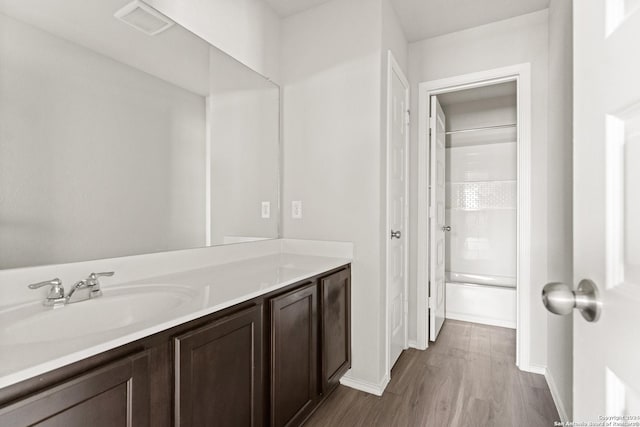 bathroom with shower / washtub combination, wood-type flooring, and vanity