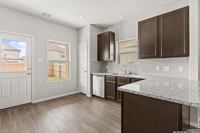 kitchen with sink, light hardwood / wood-style flooring, dark brown cabinets, light stone counters, and stainless steel dishwasher