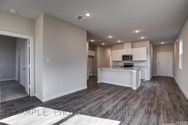 kitchen featuring dark wood-type flooring, sink, white cabinetry, appliances with stainless steel finishes, and light stone countertops