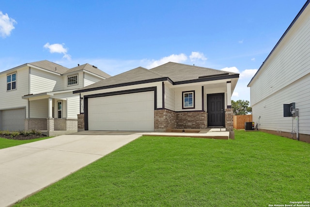 view of front of property featuring central air condition unit, a front yard, and a garage