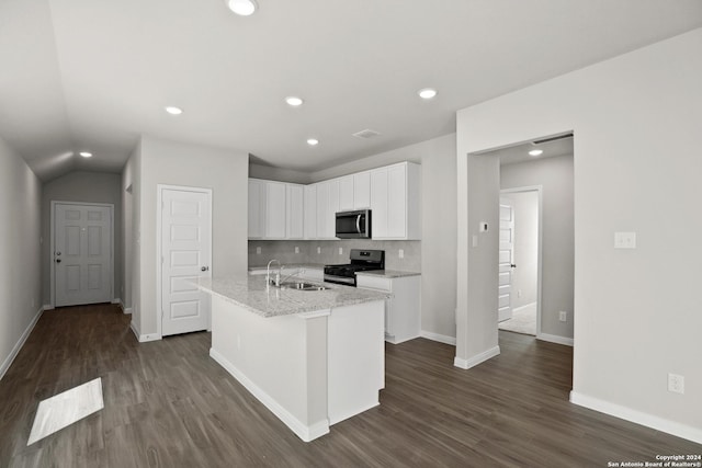 kitchen featuring light stone counters, decorative backsplash, a kitchen island with sink, white cabinets, and appliances with stainless steel finishes