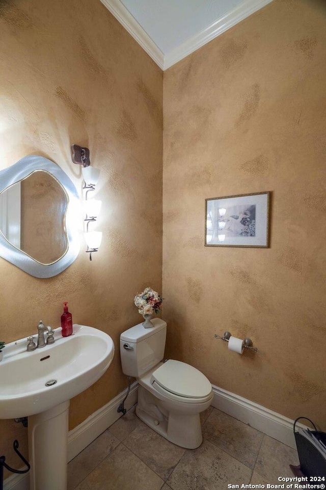 bathroom featuring crown molding and toilet