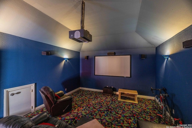 cinema room with lofted ceiling and carpet flooring