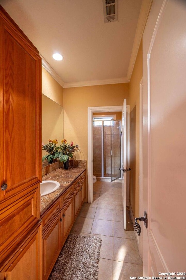 bathroom featuring vanity, an enclosed shower, toilet, crown molding, and tile patterned floors