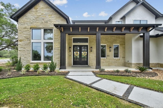 property entrance with a lawn and covered porch