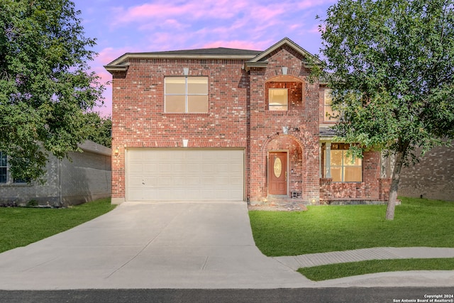 front facade with a garage and a lawn