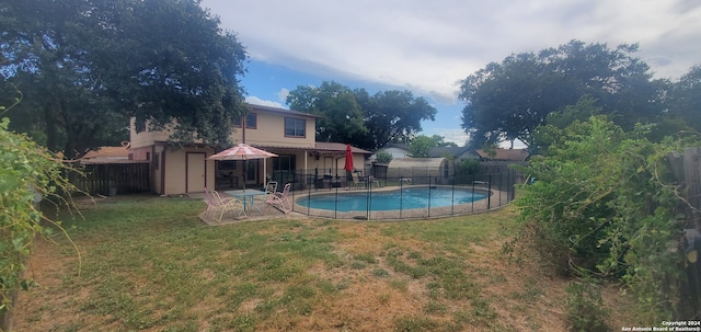 view of swimming pool featuring a lawn and a patio