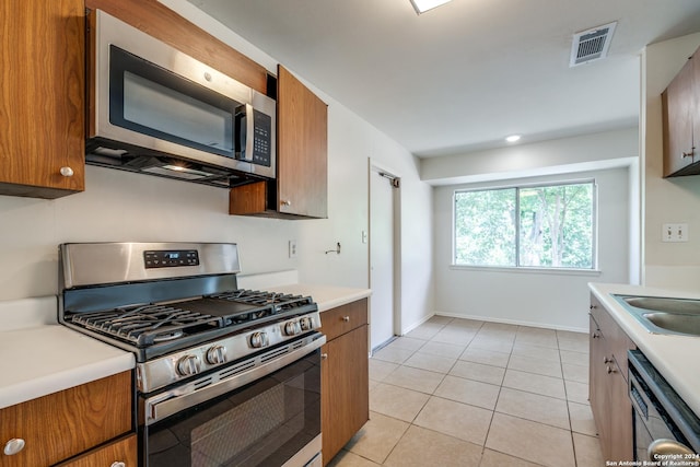 kitchen with sink, appliances with stainless steel finishes, and light tile patterned floors