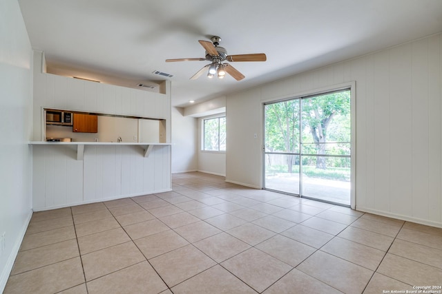 tiled spare room with ceiling fan