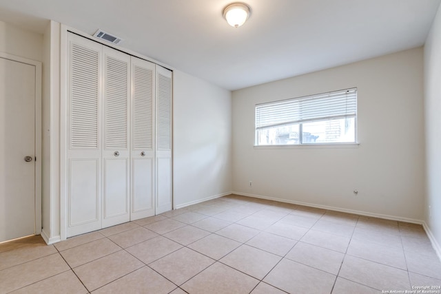 unfurnished bedroom featuring a closet and light tile patterned floors