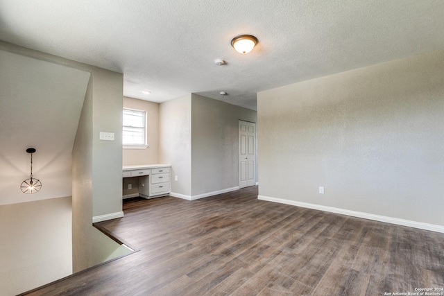 spare room with dark wood-type flooring and a textured ceiling