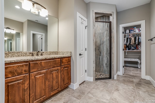 bathroom featuring tiled shower, tile patterned floors, and vanity