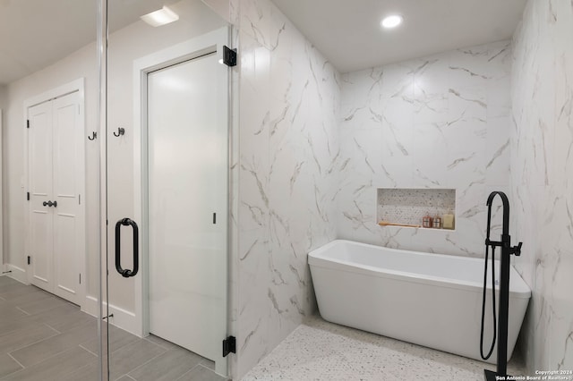 bathroom featuring tile patterned flooring and tile walls