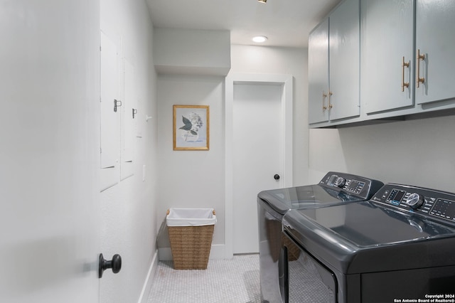 clothes washing area with cabinets, light tile patterned flooring, and independent washer and dryer