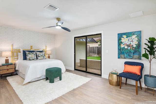 bedroom with brick wall, access to outside, ceiling fan, and hardwood / wood-style floors