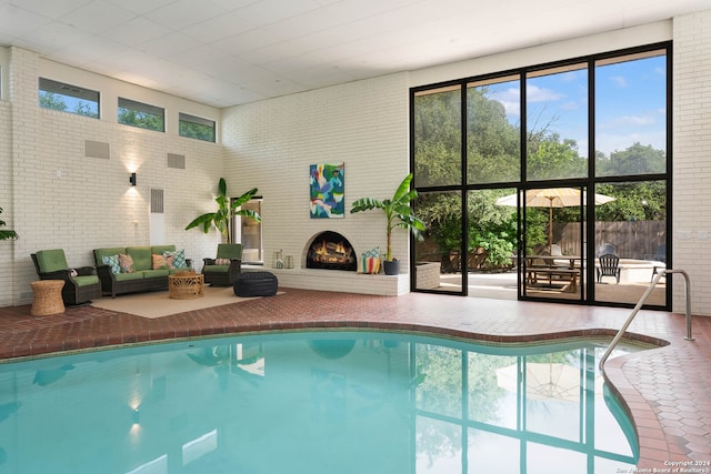 view of swimming pool featuring a brick fireplace