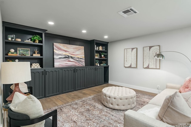 living room with wood-type flooring and built in features