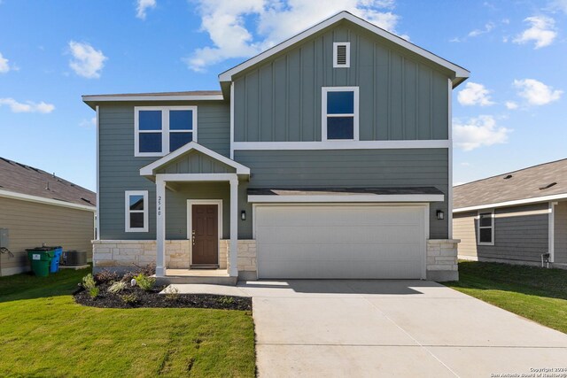 view of front of property with a garage, a front yard, and central air condition unit