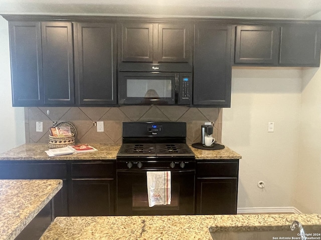 kitchen featuring backsplash, light stone counters, sink, and black appliances