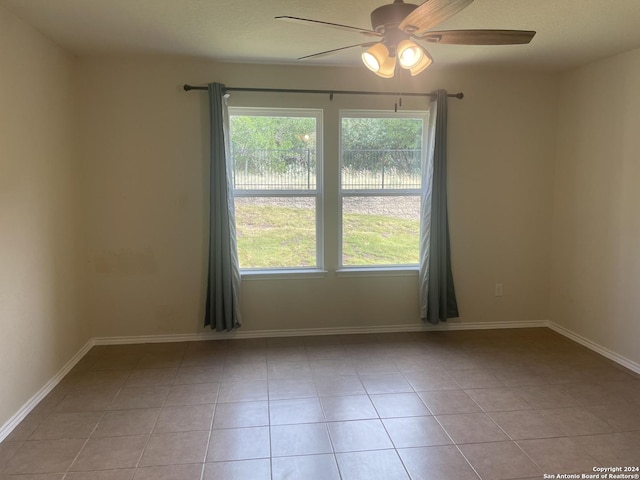 unfurnished room with light tile patterned floors and ceiling fan