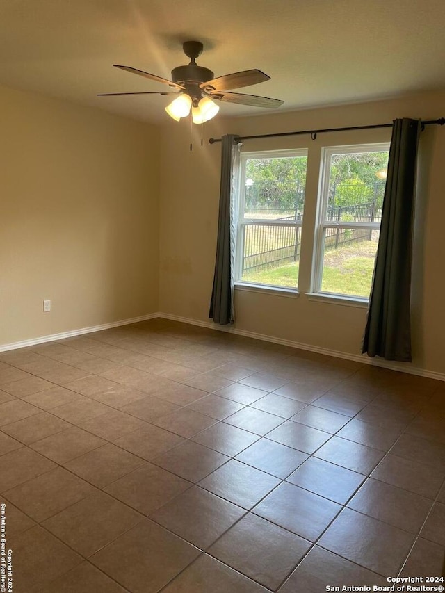 tiled empty room featuring ceiling fan