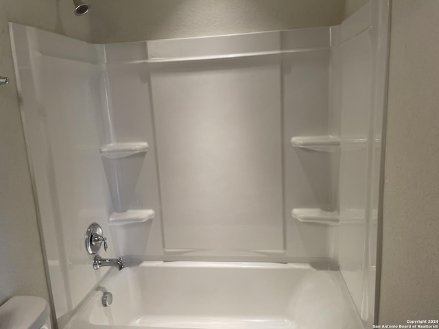 bathroom featuring washtub / shower combination and toilet