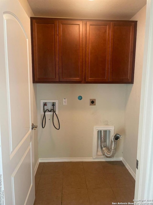 laundry area featuring hookup for an electric dryer, cabinets, dark tile patterned flooring, and washer hookup