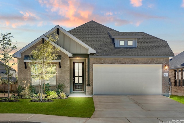 view of front of property featuring a garage and a lawn