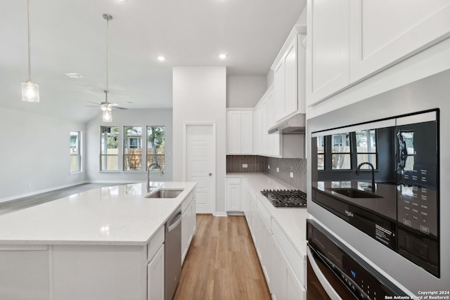 kitchen with a kitchen island with sink, sink, white cabinets, and appliances with stainless steel finishes