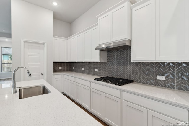 kitchen featuring light stone countertops, sink, white cabinets, and stainless steel gas cooktop