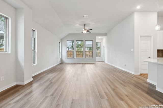 unfurnished living room with ceiling fan, vaulted ceiling, and light wood-type flooring