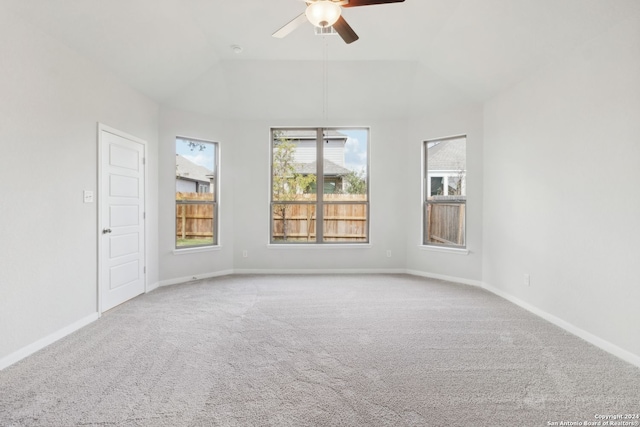 carpeted empty room with ceiling fan and vaulted ceiling