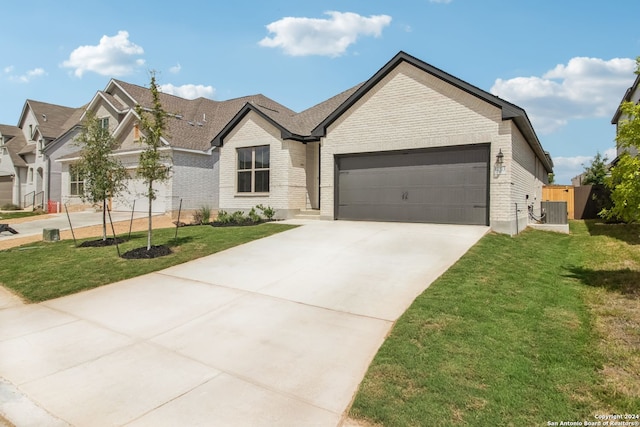 view of front facade with a garage, a front yard, and cooling unit