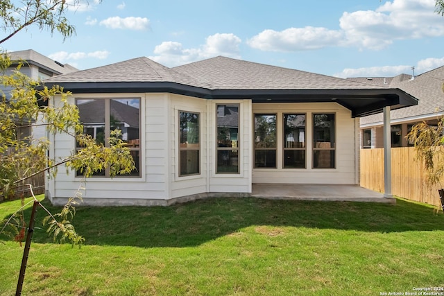 rear view of property with a yard and a patio