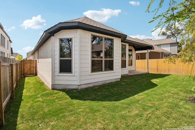 rear view of property featuring a lawn