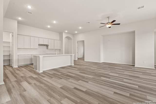 unfurnished living room with ceiling fan, sink, and light hardwood / wood-style flooring