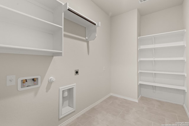 laundry area featuring hookup for a washing machine, electric dryer hookup, gas dryer hookup, and light tile patterned floors