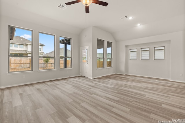 unfurnished living room with plenty of natural light, light wood-type flooring, and lofted ceiling