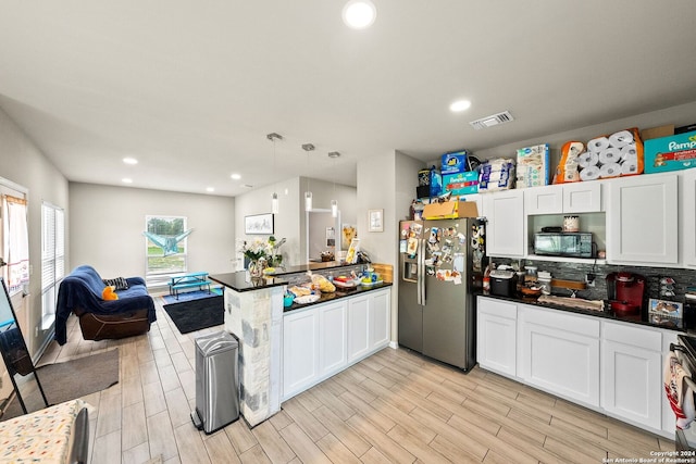 kitchen with stainless steel fridge, backsplash, white cabinets, decorative light fixtures, and kitchen peninsula