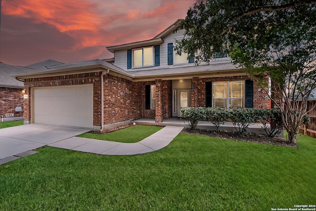 view of front of home featuring a garage, a yard, and covered porch